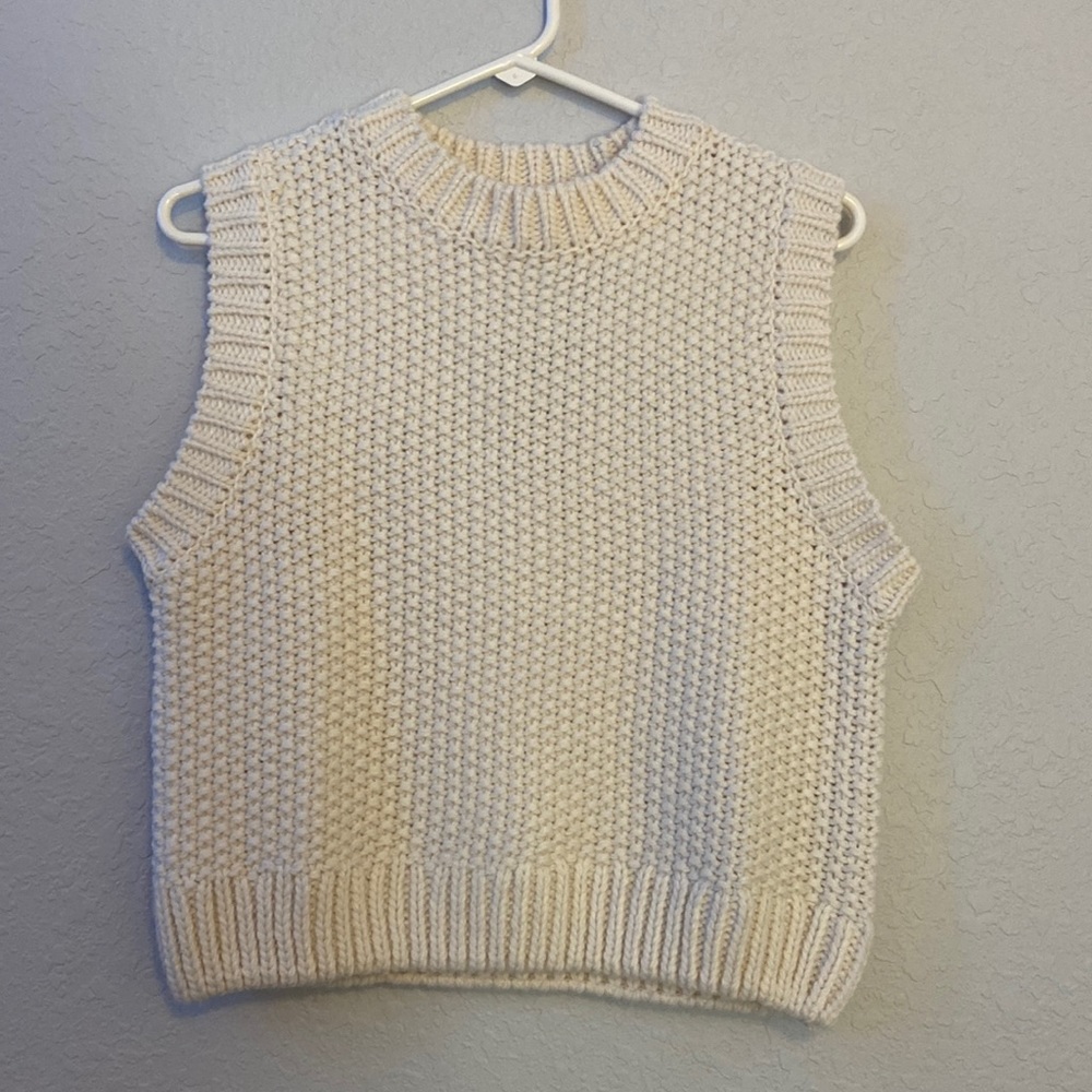 A cream colored Knit sweater vest